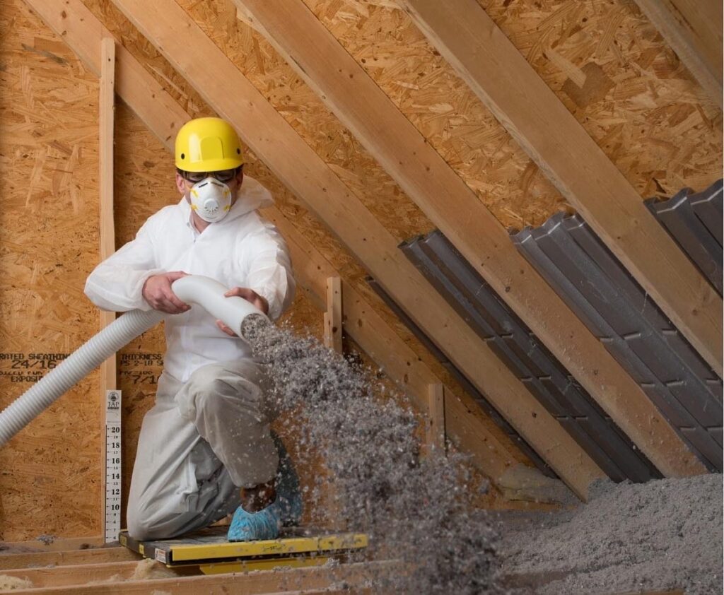 Technician installing new blown-in insulation